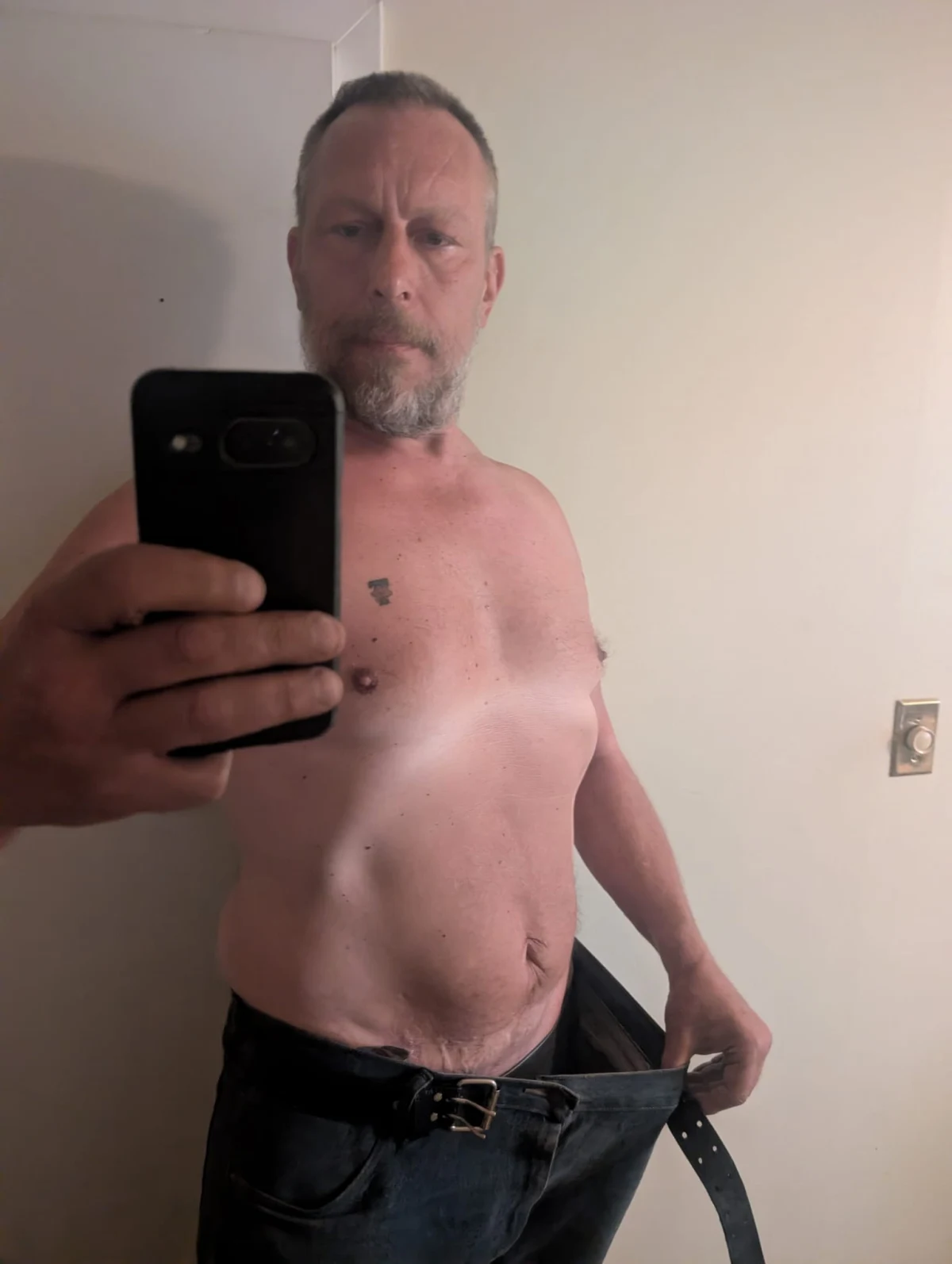Tom Hipsz holding out the waistband of his old jeans